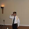 Post Commander Joe Filice stands and salute the Presentation Colors